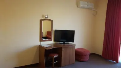 a room with a desk with a television and a mirror at Hotel Black Sea - Breakfast, Pool & Free Parking in Obzor
