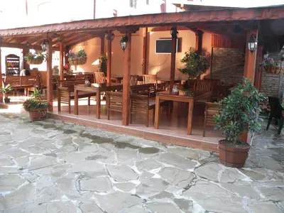 a restaurant with wooden tables and chairs and plants at Hotel Black Sea - Breakfast, Pool & Free Parking in Obzor