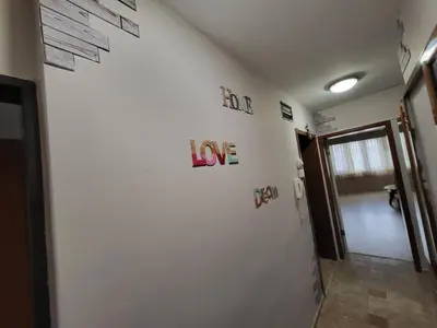 a hallway with a white wall with letters on it at Lux Apartment Sisi in Burgas City