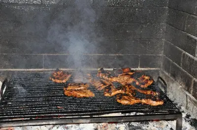 a bunch of meat cooking on a grill at Hotel BelleVille in Sunny Beach
