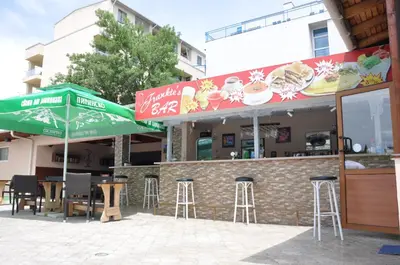 a restaurant with tables and chairs and umbrellas at Hotel BelleVille in Sunny Beach