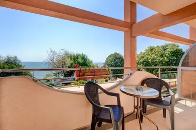 a balcony with two chairs and a table and a railing at Hotel Capri in Nesebar