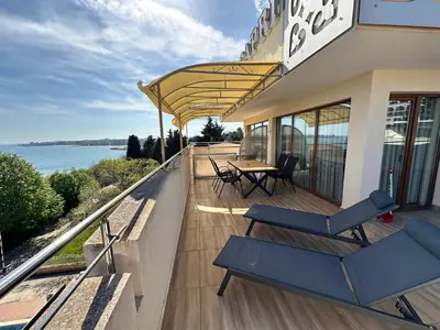 a balcony of a building with a table and chairs at Hotel Capri in Nesebar