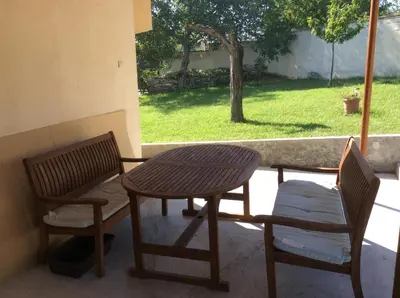 a wooden table and two chairs and a table and a table at Villa Tunley in Razvalini Balchikioy
