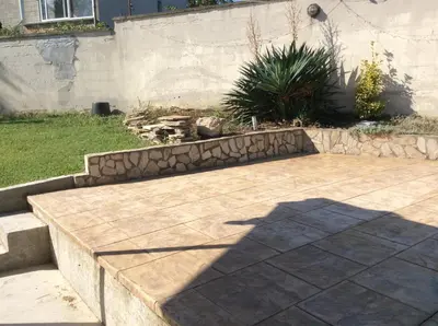 a patio in a yard with a retaining wall at Villa Tunley in Razvalini Balchikioy