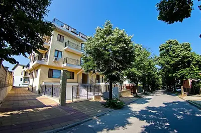 a building on a street with trees in front of it at Galata in Varna City