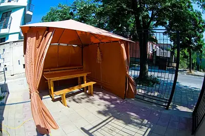 a wooden bench under an umbrella next to a gate at Galata in Varna City