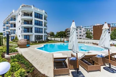 a swimming pool with chairs and a building at Morning Star Deluxe in Chernomorets