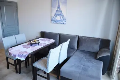 a living room with a couch and a table and chairs at Ivanovi Apartments in Burgas City
