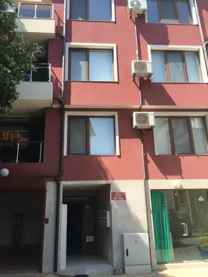 a red building with a green door at Apartment Martin Beach in Pomorie