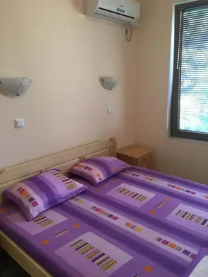 a bed in a room with purple sheets and pillows at Apartment Martin Beach in Pomorie