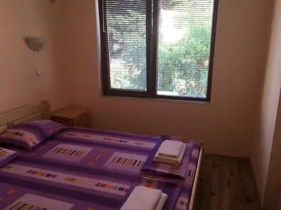 a bedroom with a purple bed with a window at Apartment Martin Beach in Pomorie