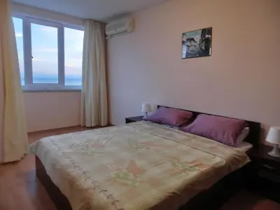 a bedroom with a bed and a large window at Sea View Crown apartment on complex with pools and beach, Sveti Vlas in Sveti Vlas