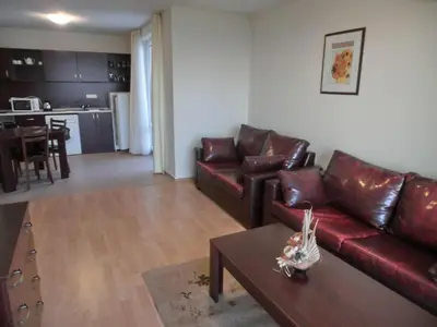a living room with a red leather couch and a table at Sea View Crown apartment on complex with pools and beach, Sveti Vlas in Sveti Vlas