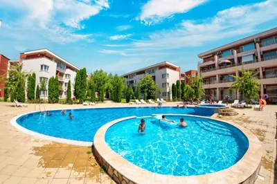 a swimming pool in a resort with people in it at Nessebar Fort Club Apartments in Sunny Beach
