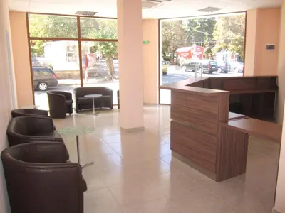 a lobby with a desk and chairs in a building at Hotel COOP Central in Obzor