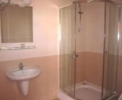 a bathroom with a shower and a sink and a tub at Hotel COOP Central in Obzor