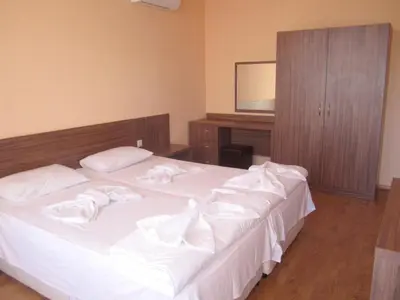a bedroom with two beds with white sheets at Hotel COOP Central in Obzor