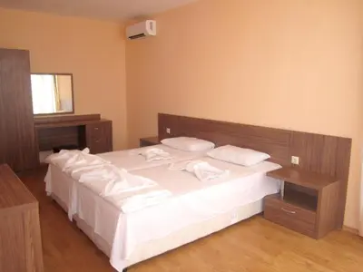 a bedroom with a large bed with white sheets and pillows at Hotel COOP Central in Obzor