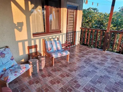 a porch with a couch and chairs on a house at Sunset House in Varna City