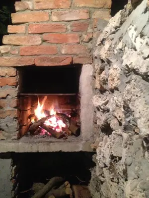 a brick oven with a fire in it at Sunset House in Varna City