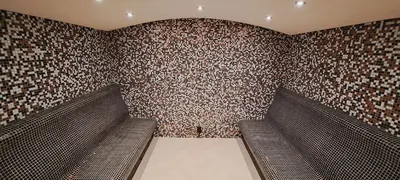 a room with two benches in a brick wall at Paradise Hotel & Relax Center in Pomorie
