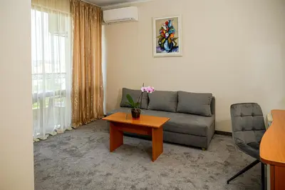 a living room with a couch and a table at Paradise Hotel & Relax Center in Pomorie