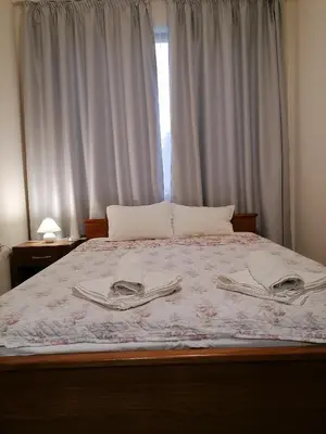 a bed with two towels on it with a window at White home-apartament in Burgas City