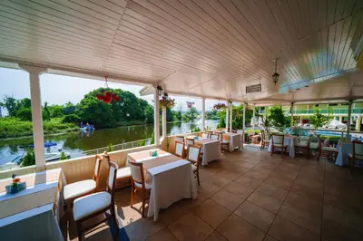 a restaurant with tables and chairs and a view of a river at Perla Sun Beach Hotel - All Inclusive in Primorsko