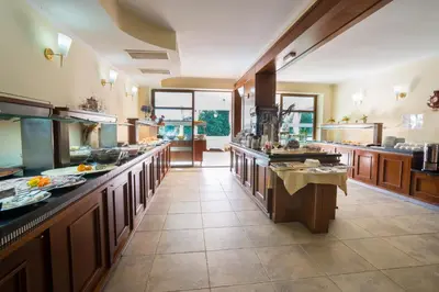a large kitchen with wooden cabinets and counters at Perla Sun Beach Hotel - All Inclusive in Primorsko