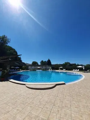 a large blue swimming pool on a tile patio at Balaton Hotel in Sunny Beach