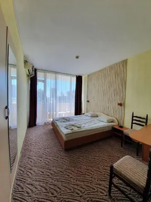 a hotel room with a bed and a large window at Balaton Hotel in Sunny Beach