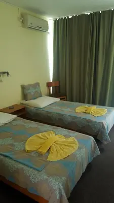 two beds in a room with yellow robes on them at Balaton Hotel in Sunny Beach