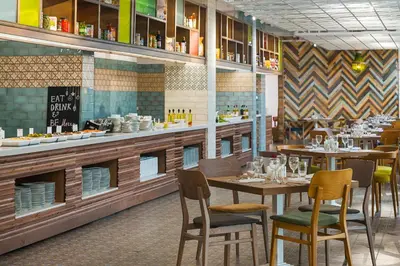 a restaurant with tables and chairs and a counter at Sunrise Blue Magic Resort - All Inclusive in Obzor