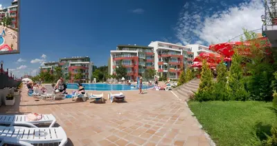 a group of people sitting around a swimming pool at Green Fort Private Apartments in Sunny Beach