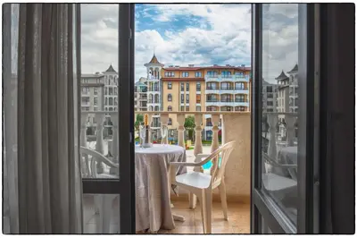 a room with a table and a view of a building at Royal Sun Apartments in Sunny Beach