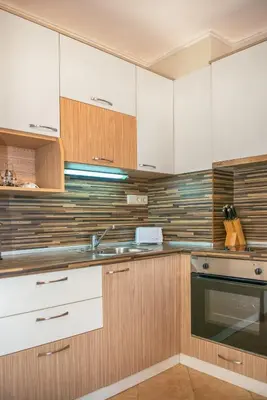 a kitchen with wooden cabinets and a sink at Royal Sun Apartments in Sunny Beach