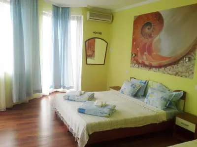 a bedroom with a bed with blue pillows on it at Aquamarine in Sozopol