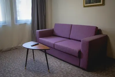 a purple couch in a living room with a table at Prince Cyril Hotel in Nesebar