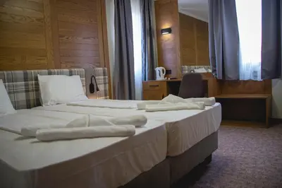 two beds in a hotel room with towels on them at Prince Cyril Hotel in Nesebar