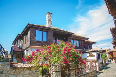 a wooden house with flowers in front of it at Prince Cyril Hotel in Nesebar
