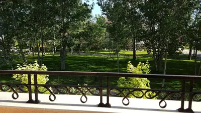 a bench on a balcony looking out at a park at Aphrodite Rose Apartment in Sunny Beach