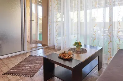 a living room with a table with a bowl of fruit on it at Hotel Sea Star Приморско in Primorsko