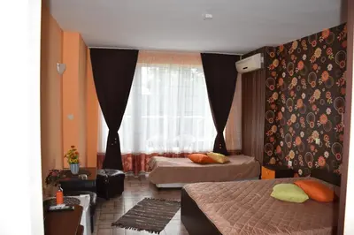 a bedroom with two beds and a window at Hotel Sea Star Приморско in Primorsko