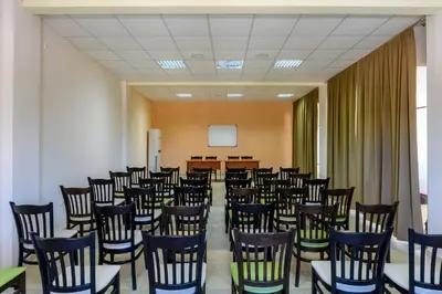a room with a bunch of chairs and a screen at Midia Family Resort All-Inclusive in Aheloy