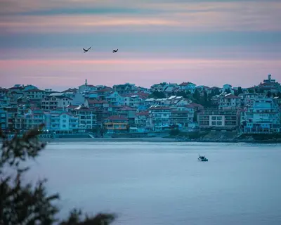 a boat in the water in front of a city at Relax Sozopol in Sozopol