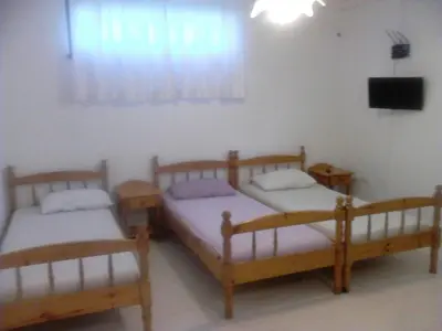 three wooden beds in a room with a television at GoodRest Nesebar in Nesebar