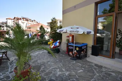 a drink stand with an umbrella next to a building at Kandrovi Sozopol in Sozopol