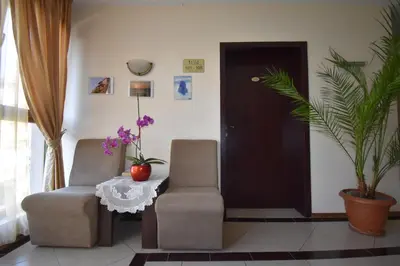 a living room with two chairs and a table at Kandrovi Sozopol in Sozopol