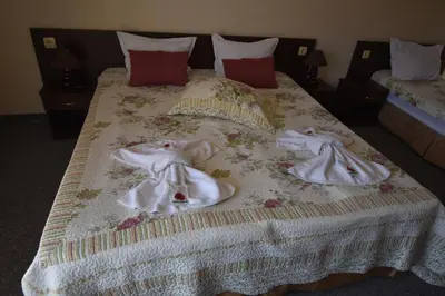 two babies dressed in white are on a bed at Kandrovi Sozopol in Sozopol
